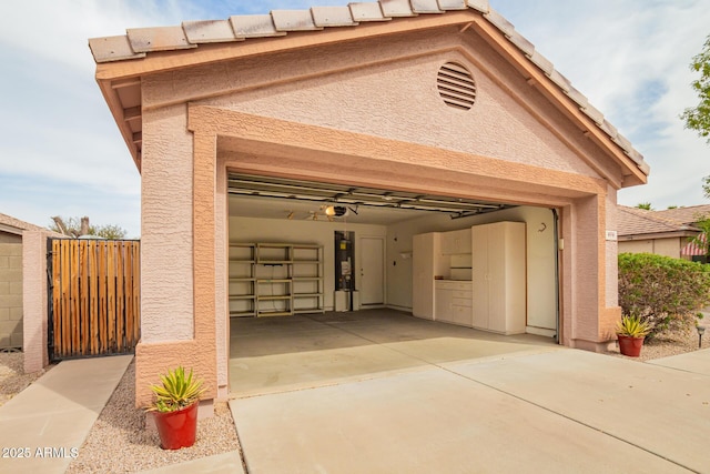 garage with a garage door opener, water heater, a gate, fence, and driveway