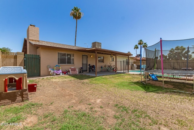 1263 W Del Rio St, Chandler, AZ 85224 - rear view of house featuring a trampoline, a fenced backyard, a chimney, and a patio area