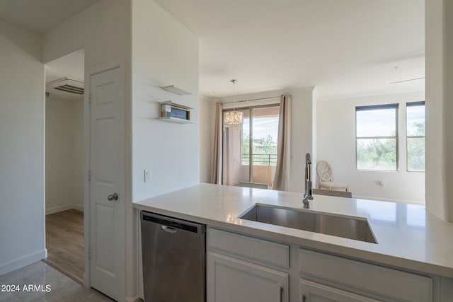 kitchen with stainless steel dishwasher, sink, decorative light fixtures, and a wealth of natural light