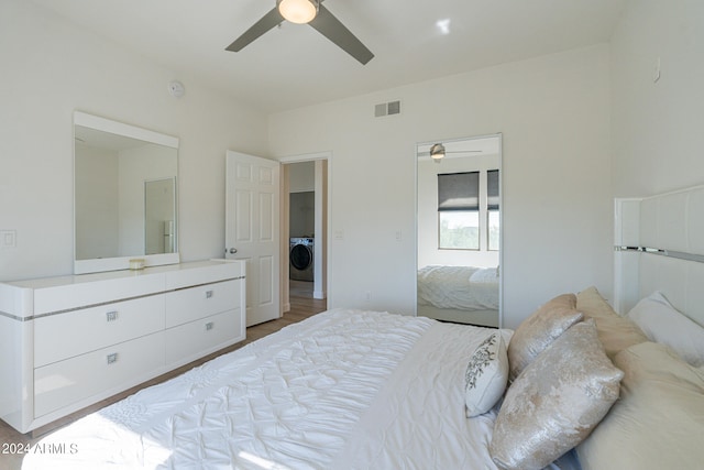 bedroom featuring washer / dryer, hardwood / wood-style flooring, and ceiling fan