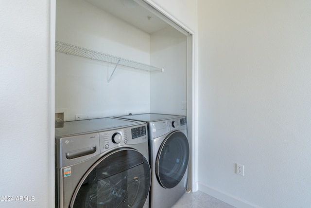 laundry area with washer and dryer and light tile patterned floors