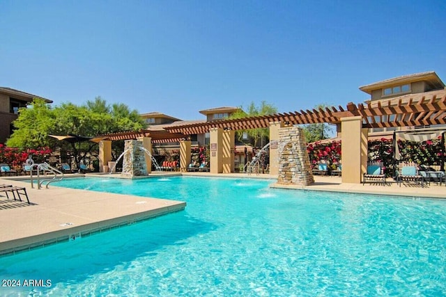 view of pool featuring pool water feature, a patio area, and a pergola