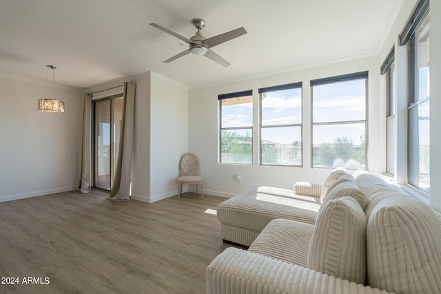 living room with crown molding, wood-type flooring, and ceiling fan