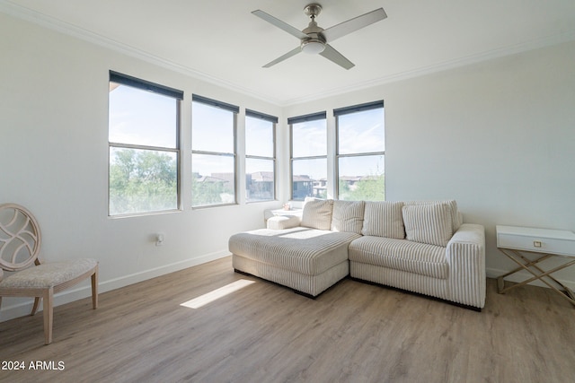 living room featuring crown molding, light hardwood / wood-style floors, and ceiling fan