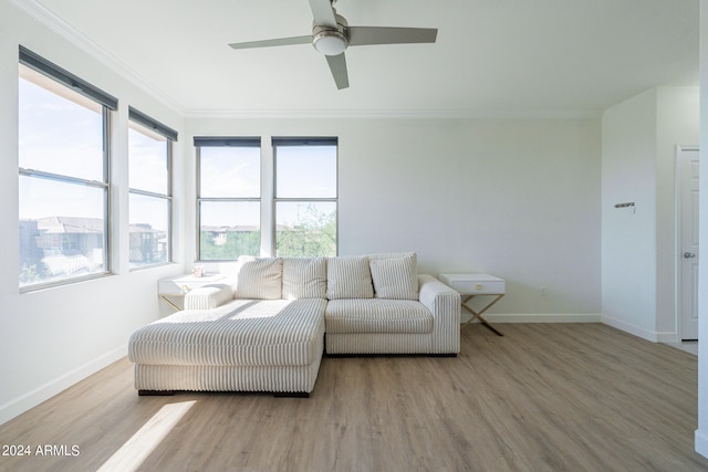 living room featuring crown molding, light wood-type flooring, and ceiling fan