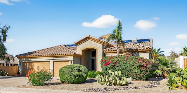 10897 S Turtle Dove Dr S, Goodyear, AZ 85338 - mediterranean / spanish house featuring a garage, a tiled roof, solar panels, stucco siding, and concrete driveway