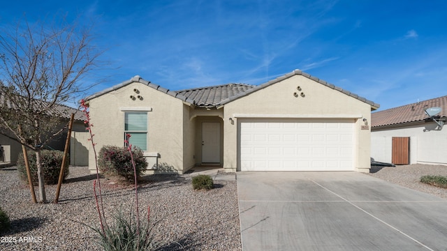 view of front of home with driveway, an attached garage, a tile roof, and stucco siding