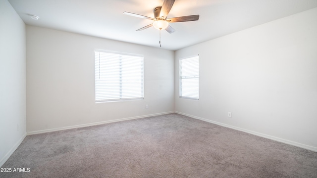 spare room featuring light carpet, ceiling fan, and baseboards