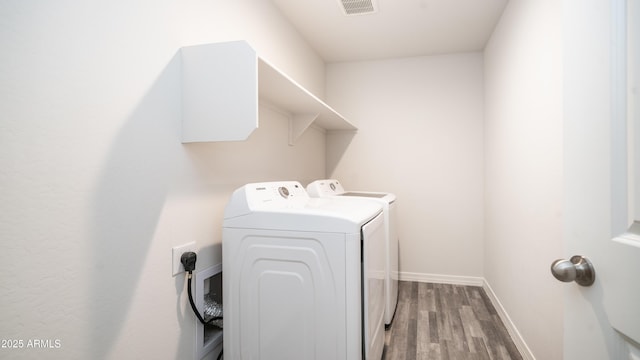 laundry room featuring laundry area, baseboards, visible vents, wood finished floors, and washer and dryer