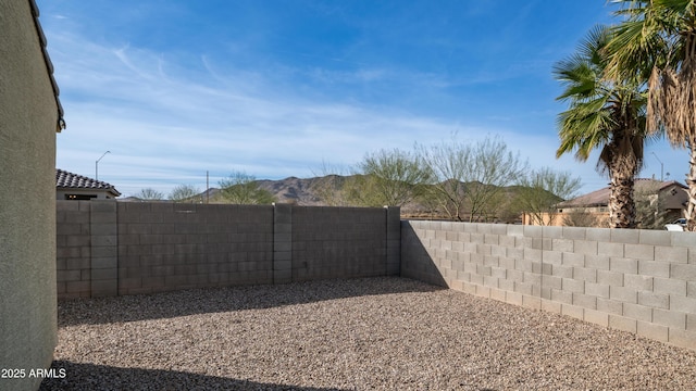 view of yard with a fenced backyard and a mountain view