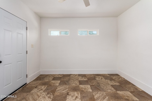 tiled spare room featuring ceiling fan