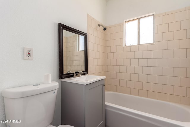 full bathroom featuring tiled shower / bath combo, toilet, and vanity