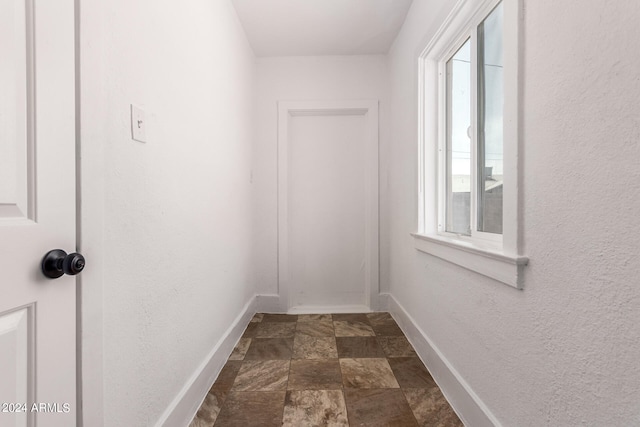 hallway with dark tile patterned floors