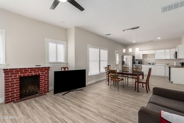 living room featuring ceiling fan, light hardwood / wood-style flooring, and plenty of natural light