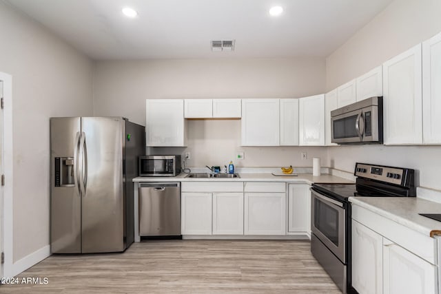 kitchen featuring light hardwood / wood-style floors, sink, white cabinetry, and stainless steel appliances