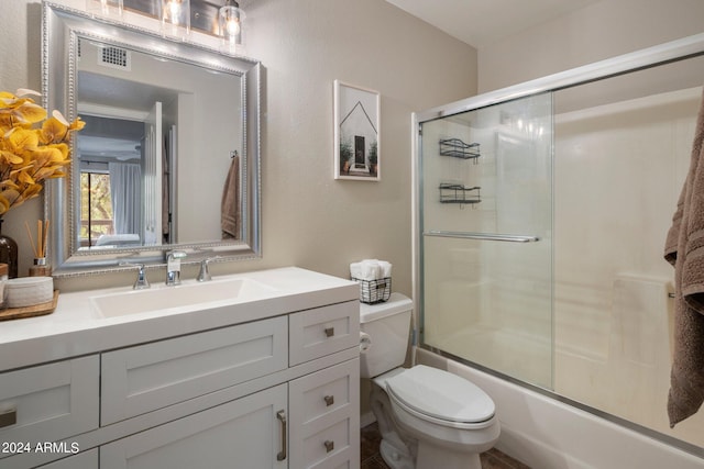 full bathroom featuring toilet, vanity, and combined bath / shower with glass door