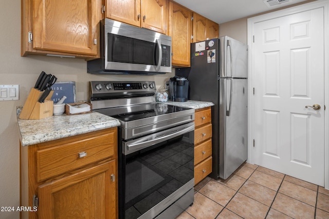 kitchen featuring stainless steel appliances and light tile patterned floors