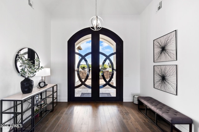 foyer entrance featuring dark hardwood / wood-style floors, a chandelier, and french doors