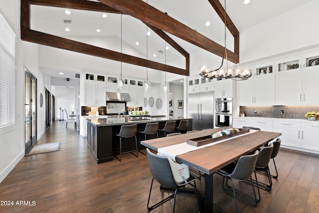 dining room featuring a notable chandelier, beam ceiling, dark wood-type flooring, and high vaulted ceiling