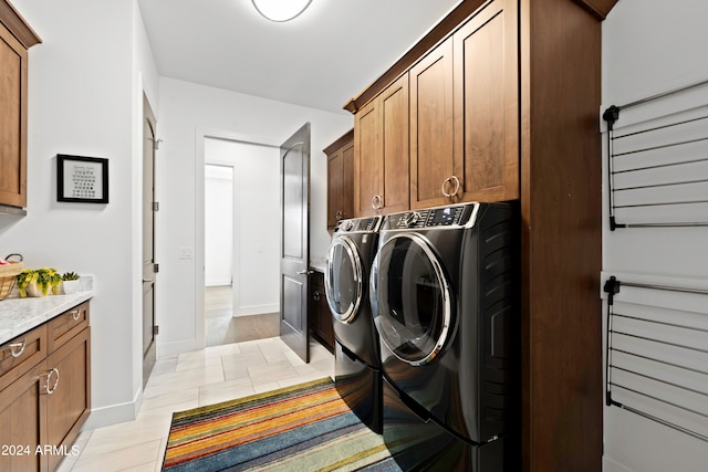 laundry area with cabinets, light wood-type flooring, and independent washer and dryer