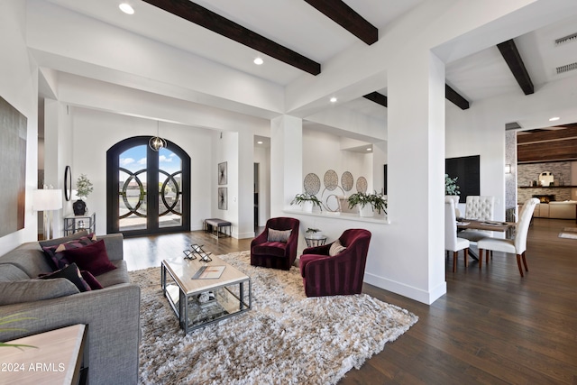 living room featuring beam ceiling, dark hardwood / wood-style flooring, a chandelier, and french doors