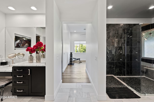 bathroom featuring tiled shower, vanity, and hardwood / wood-style floors