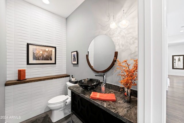 bathroom with vanity, tile walls, toilet, and hardwood / wood-style flooring