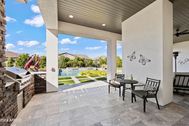 view of patio featuring area for grilling, ceiling fan, and an outdoor kitchen