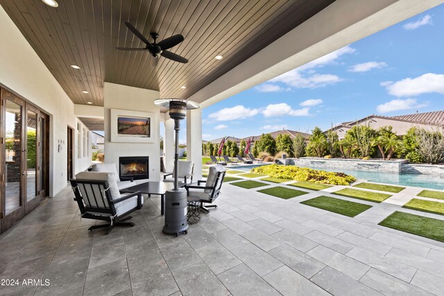 view of patio / terrace featuring exterior fireplace and ceiling fan