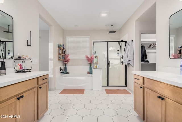 bathroom with tile patterned floors, vanity, and shower with separate bathtub