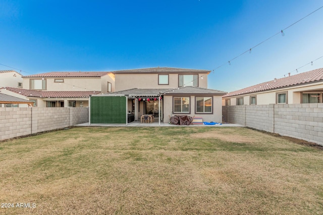 back of property with a yard and a patio