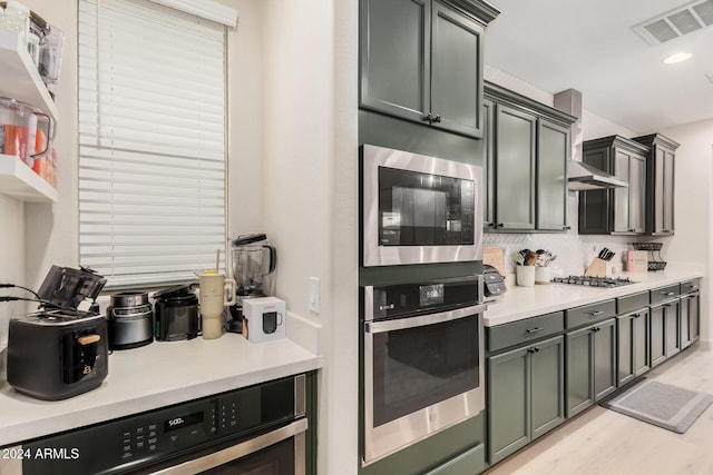 kitchen featuring wine cooler, backsplash, stainless steel appliances, and light hardwood / wood-style flooring