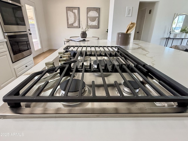 1421 W Pasadena Ave, Phoenix, AZ 85013 - detailed view of appliances with stainless steel finishes, white cabinets, light stone countertops, and light wood finished floors