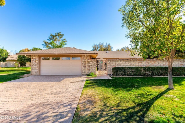 view of front of home with a front lawn, decorative driveway, and an attached garage