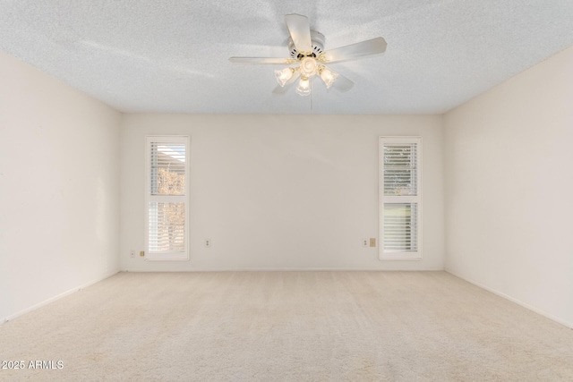 carpeted spare room featuring a ceiling fan, a healthy amount of sunlight, and a textured ceiling