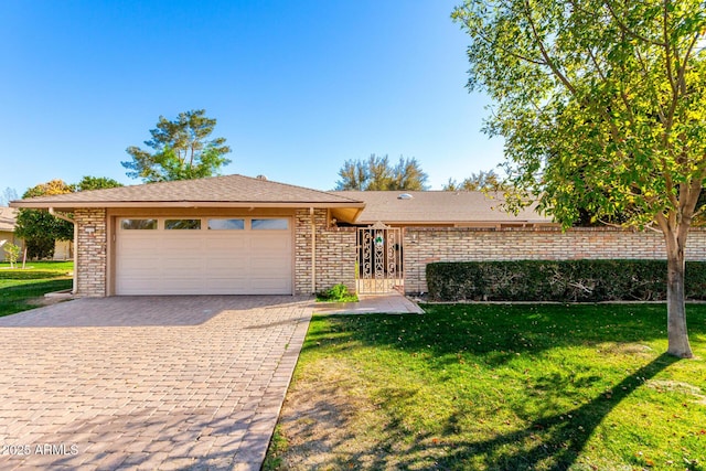 view of front of house featuring a garage, brick siding, decorative driveway, and a front yard