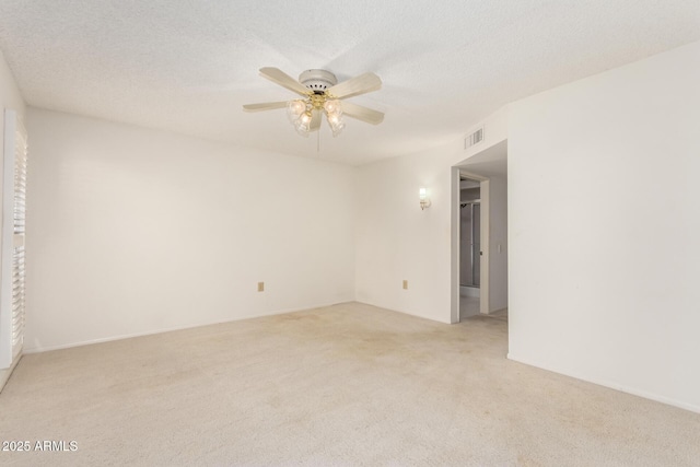 unfurnished room featuring a textured ceiling, ceiling fan, visible vents, and light colored carpet