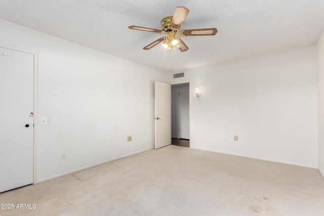 unfurnished room with carpet floors, a textured ceiling, visible vents, and a ceiling fan