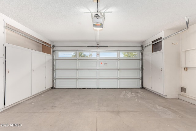 garage with a garage door opener and visible vents