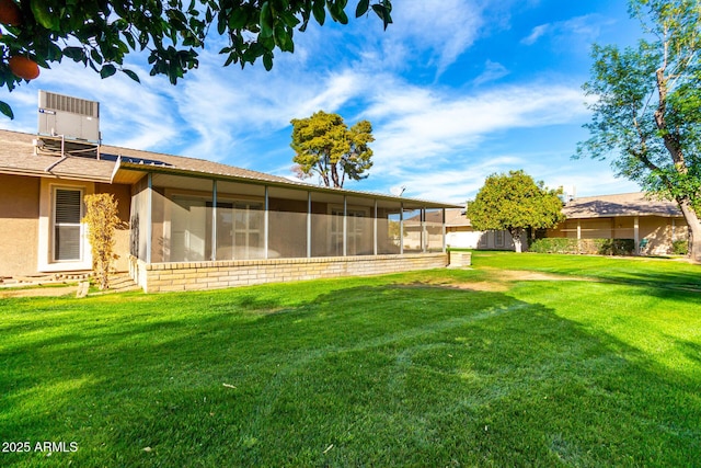 view of yard with a sunroom and central air condition unit