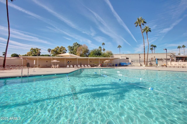 community pool with fence and a patio