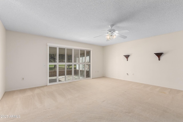 spare room with light colored carpet, ceiling fan, and a textured ceiling