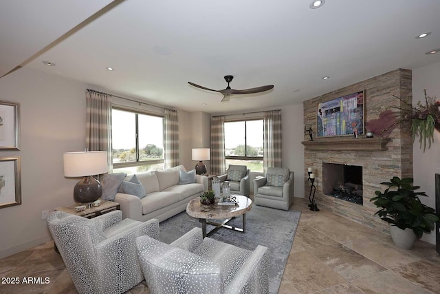 living room featuring a stone fireplace, recessed lighting, and a ceiling fan