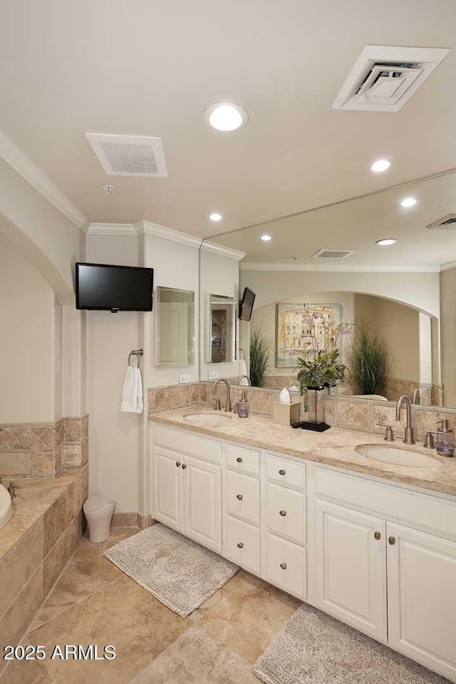 bathroom with a sink, visible vents, and crown molding