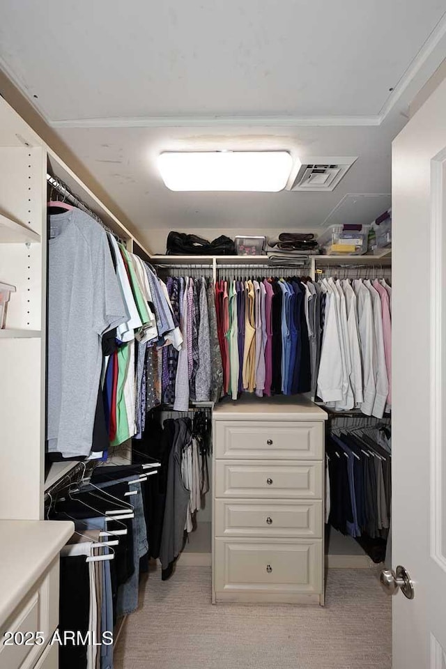 walk in closet featuring visible vents and light carpet