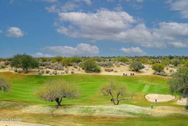 view of community with a yard and view of golf course