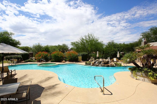 view of pool with a pool with connected hot tub and a patio