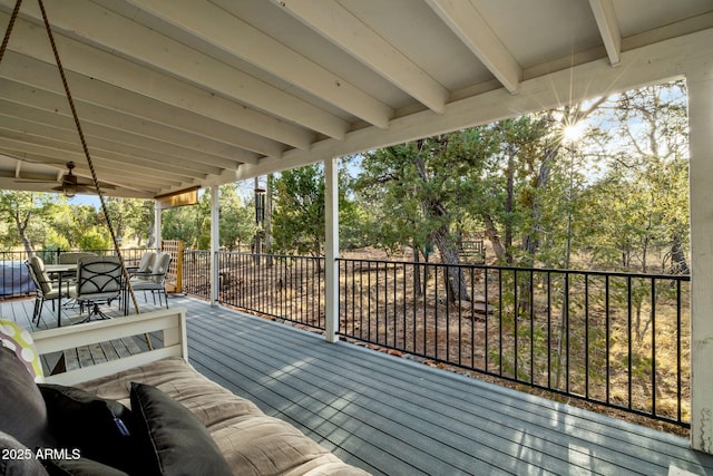 wooden terrace featuring outdoor dining area and a ceiling fan