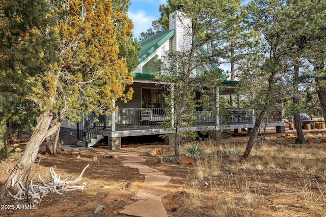 back of property with metal roof and a chimney