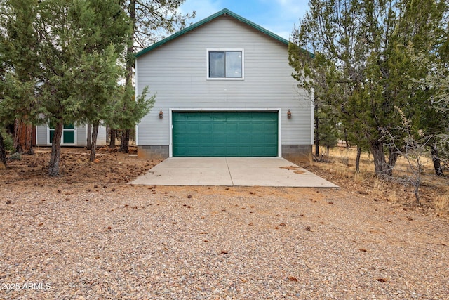 view of front of home featuring a garage and dirt driveway